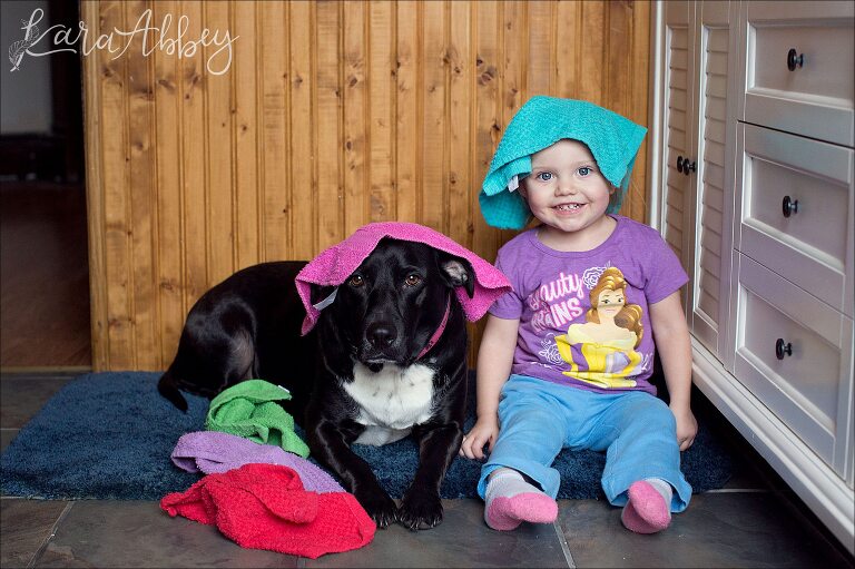 Mischievous Toddler and her Black Lab Playing with Washcloths