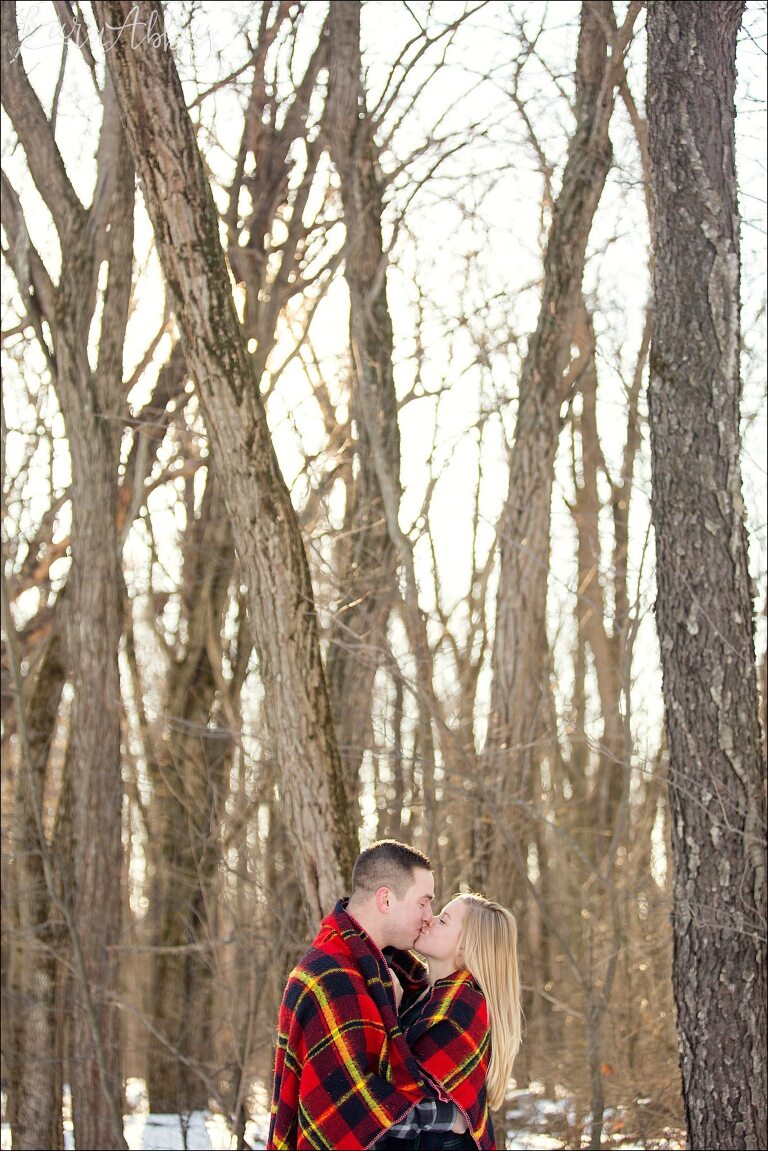 Snowy Winter Engagement Photos at Golden Hour with Red Plaid Blanket