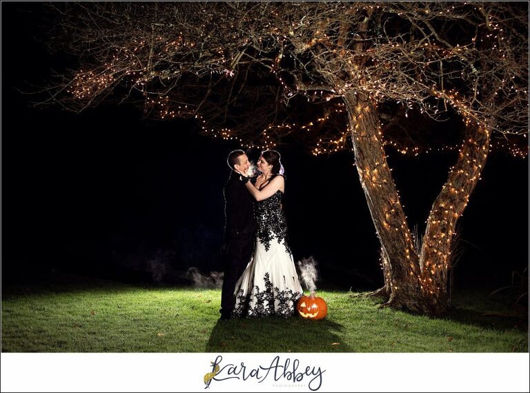 Black and Purple Disney Halloween Themed Fall Wedding at Green Gables in Jennerstown PA - Bride & Groom Night Portrait with Jack-O-Lantern Pumpkin